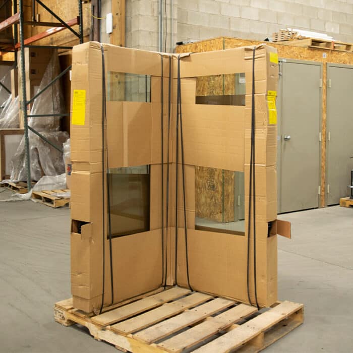 90-degree corner window sitting on pallet in original packaging in warehouse