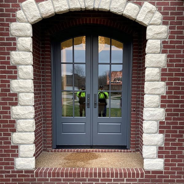 blue french doors on brick home