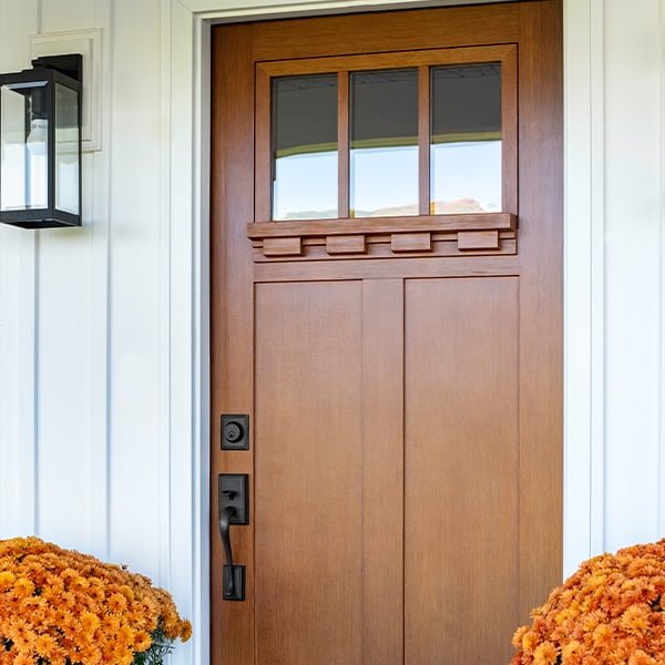 craftsman style door on house with white siding