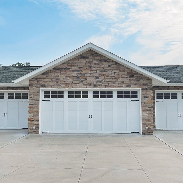 white garage doors on brick home