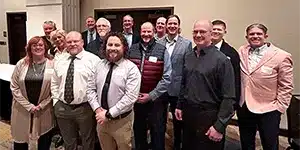 newsletter-thumbnail-2024-01 large group of adults wearing business professional clothing at a corporate event