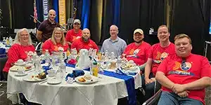 adults sitting at a table during a corporate event