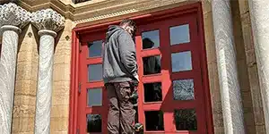 newsletter-thumbnail-2025-04 man standing on ladder near red double doors