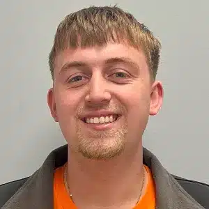 blake-petty young adult male with light brown hair, black jacket and orange shirt