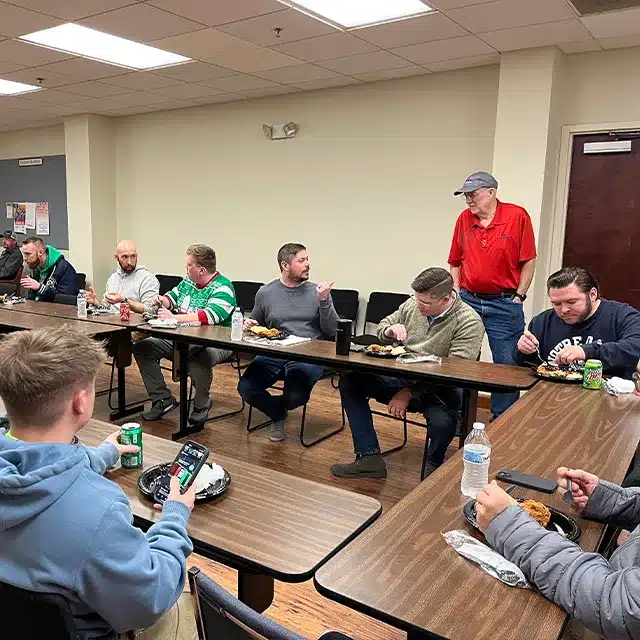 a large conference room full of working professionals eating lunch together