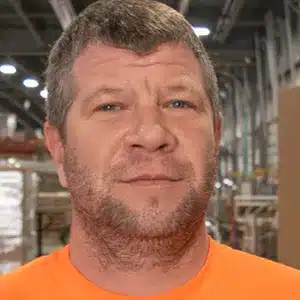 stu-sumner adult male with short brown hair, brown facial hair and orange shirt