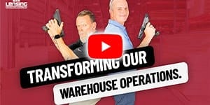 two adult males holding barcode scanners standing back to back