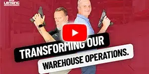 two adult males holding barcode scanners standing back to back